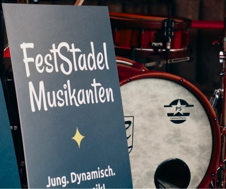Ein Aufsteller mit dem Schriftzug "Feststadelmusikanten" steht vor der Base-Drum.